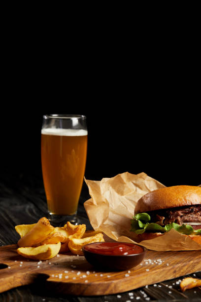 istock Tempting fast food diner with hamburger and potato served with beer 992085192