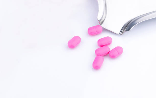 Pile of pink tablets pill on white background near stainless steel drug tray. Norfloxacin 400 mg for treatment cystitis. Antibiotics drug resistance. Antimicrobial drug use with reasonable concept. montón de píldora pastillas color rosa sobre fondo blanco junto a la bandeja de medicamentos de acero inoxidable. norfloxacina 400 mg para la cistitis tratamiento. resistencia a los medicamentos antibióticos. uso de drogas antimicrobianas con concepto r
