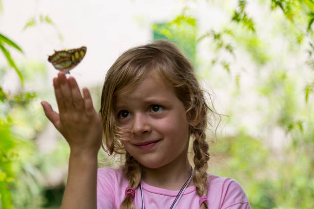 istock Blond Girl With Yellow Spotted Butterfly on Fingertips 992089262