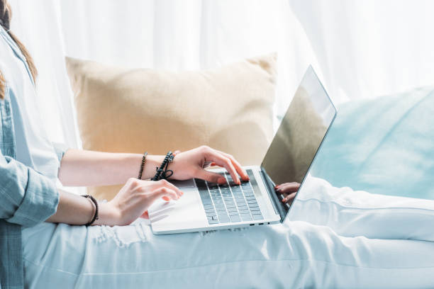 istock cropped view of woman using laptop while sitting with pillows 992089824