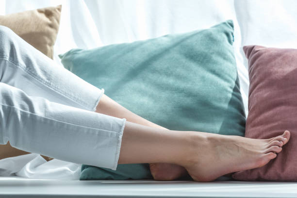 istock partial view of barefoot female legs near pillows 992094828