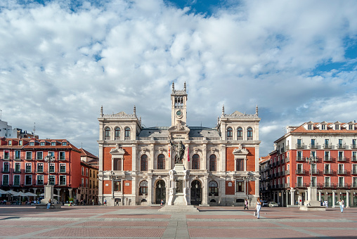 Valladolid, Castilla y León-Spain, April 14, 2022; statue tribute to the writer José de Zorrilla in the square that bears his name. Spanish poet and playwright, known for being the author of the classic Don Juan Tenorio. Next to an emblematic building illuminated at sunset.