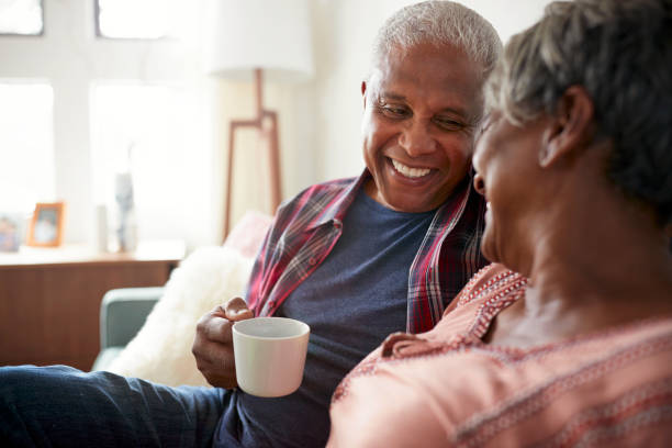 istock Senior Couple Sitting On Sofa At Home Relaxing With Hot Drink 992096676