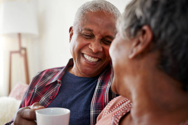 istock Senior Couple Sitting On Sofa At Home Relaxing With Hot Drink 992096894