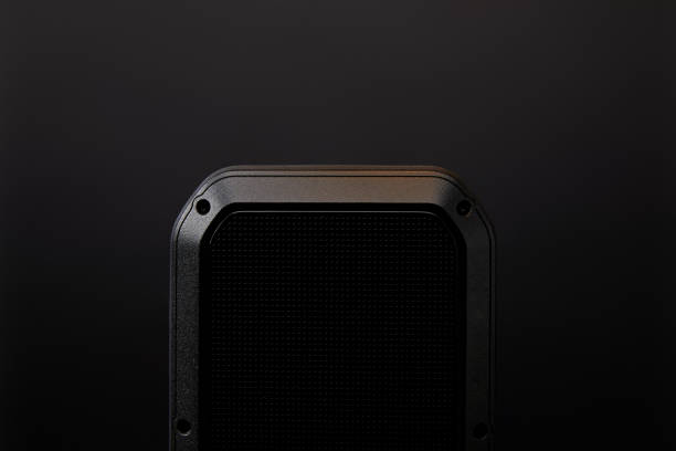 close up view of black audio speaker on black wall backdrop