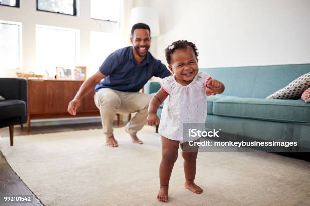 Hija De Bebé Bailando Con El Padre En El Salón En Casa Foto de stock y más banco de imágenes de Bebé