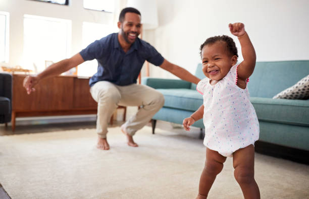baby daughter dancing with father in lounge at home - pai e filha a dançar imagens e fotografias de stock