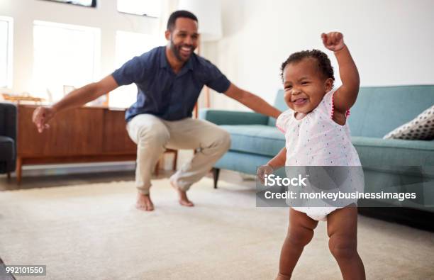 Foto de Filha De Bebê Dançando Com O Pai Na Sala De Estar Em Casa e mais fotos de stock de Bebê