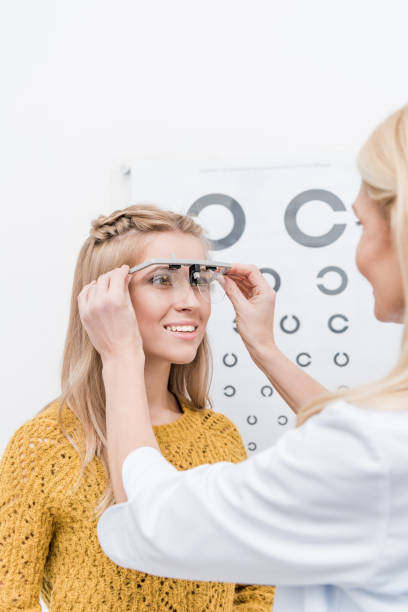istock patient and oculist with trial frame and eye chart behind 992102140
