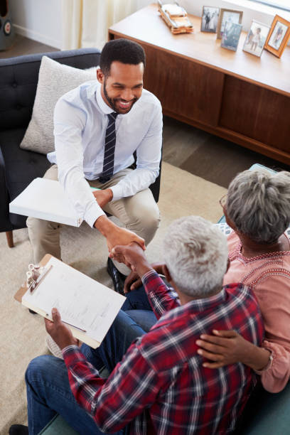 coppia senior che stringe la mano a un consulente finanziario maschio a casa - 401k retirement planning financial advisor foto e immagini stock