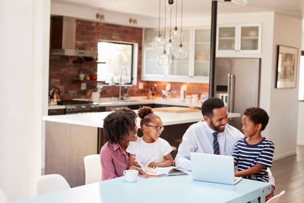 istock Parents Sitting Around Table At Home Helping Children With Homework 992105438