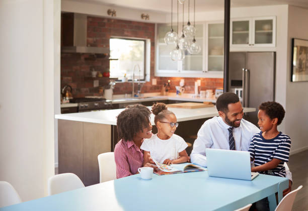istock Parents Sitting Around Table At Home Helping Children With Homework 992105586