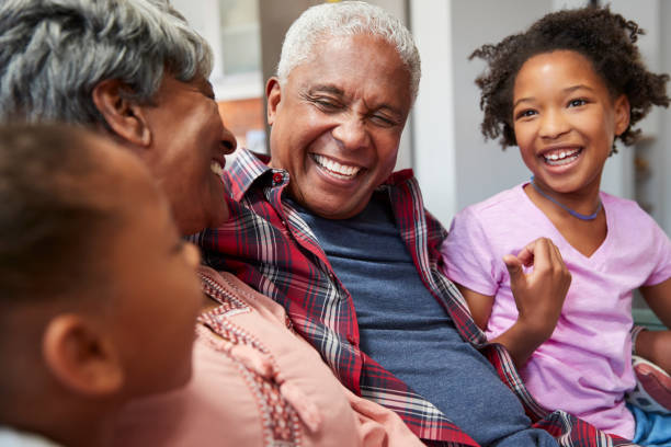 istock Grandparents Relaxing On Sofa At Home With Granddaughters 992107332