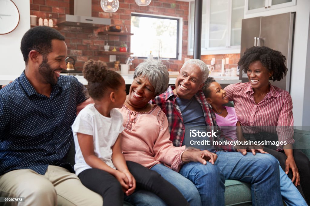 Multi Generation Family Relaxing On Sofa At Home Together Family Stock Photo