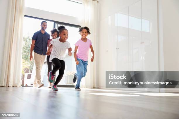 Excited Family Exploring New Home On Moving Day Stock Photo - Download Image Now - Moving House, Family, Home Ownership