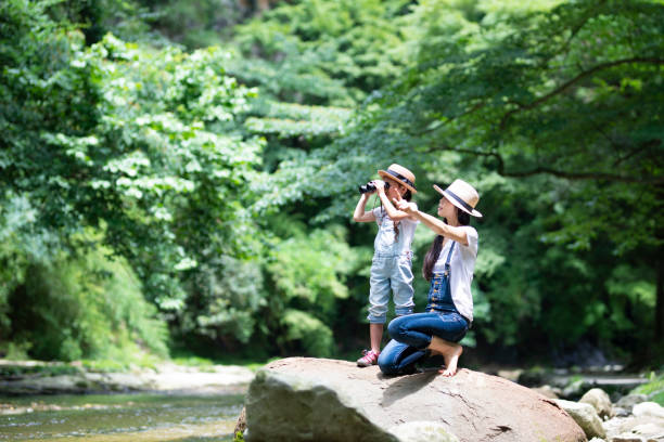 istock Mother and daughter playing in the river 992111336
