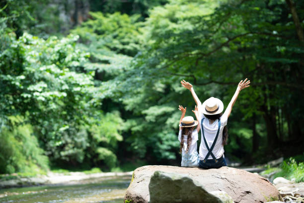istock Mother and daughter playing in the river 992111376