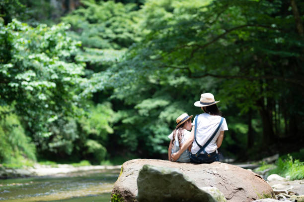 istock Mother and daughter playing in the river 992111378