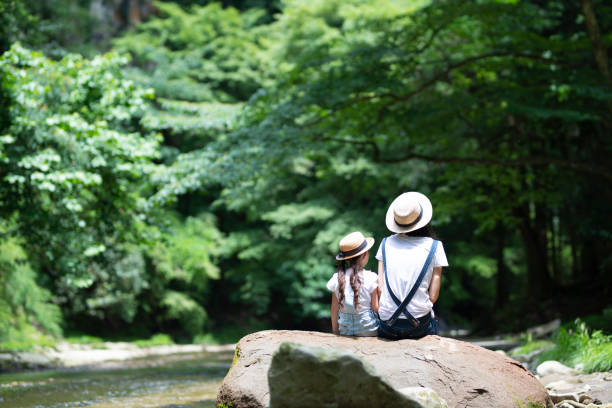 istock Mother and daughter playing in the river 992111382