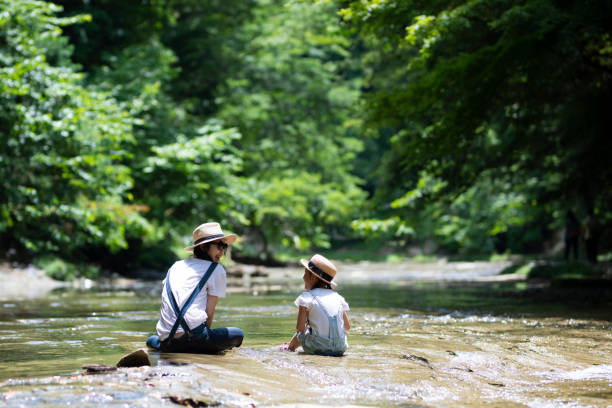 istock Mother and daughter playing in the river 992111436