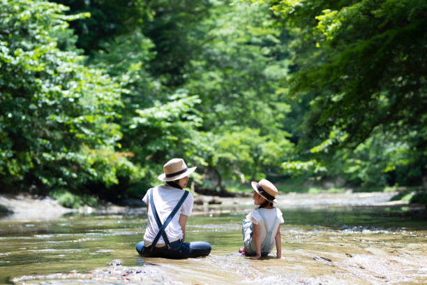 istock Mother and daughter playing in the river 992111466