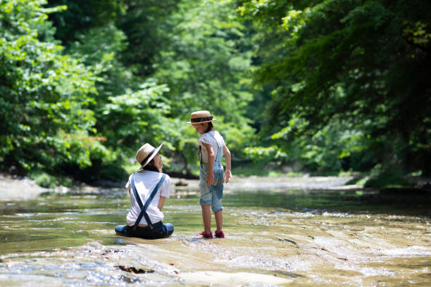 istock Mother and daughter playing in the river 992111476