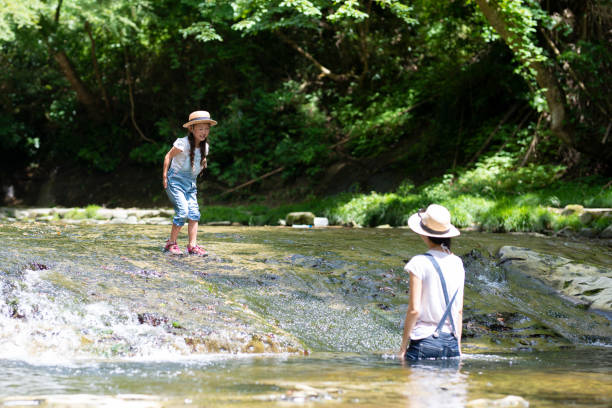 istock Mother and daughter playing in the river 992111860