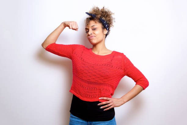 istock cool young black woman flexing bicep muscle 992112160