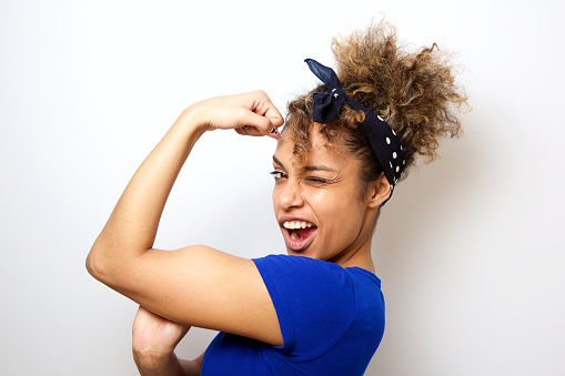 Cerrar fresca joven afroamericana flexionando los músculos bíceps photo