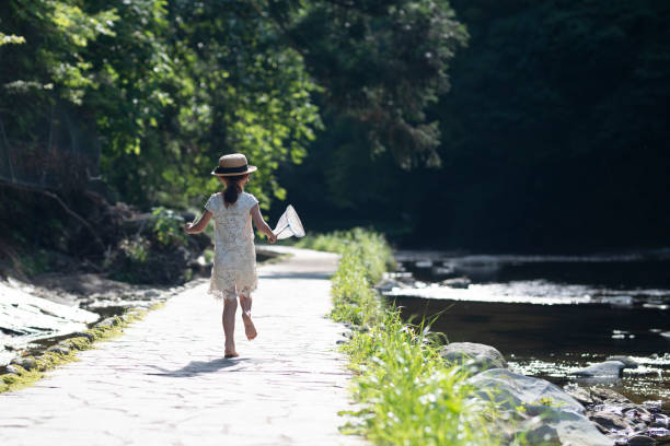 女の子 に流れる川 - 夏休み 写真 ストックフォトと画像