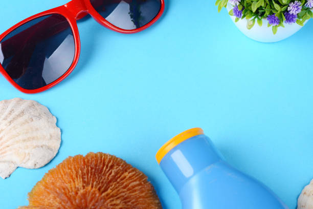 istock Top view of sunglasses, shells, starfish and sunblock 992113788