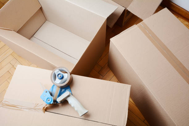 istock Tape dispenser sealing a shipping cardboard box 992118750