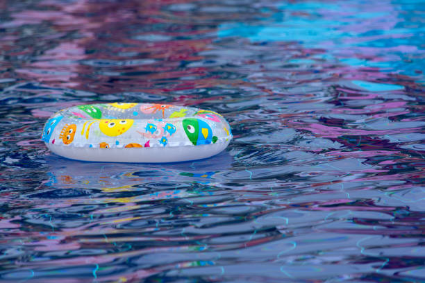 schwimmring auf blauem wasser schwimmbad mit wellen - swimming pool inner tube toy float stock-fotos und bilder