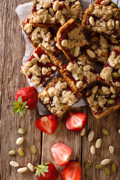 istock Oat bars with strawberries, seeds and nuts close-up on the table. Vertical top view 992124640