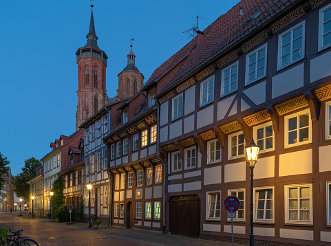 View on St. Johannis church with typical half-timbered houses in twilight at dusk in old town of Goettingen, Lower Saxony, Germany
