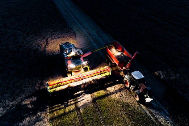 combine working on the field in the night - agricultural machinery retro revival summer farm imagens e fotografias de stock