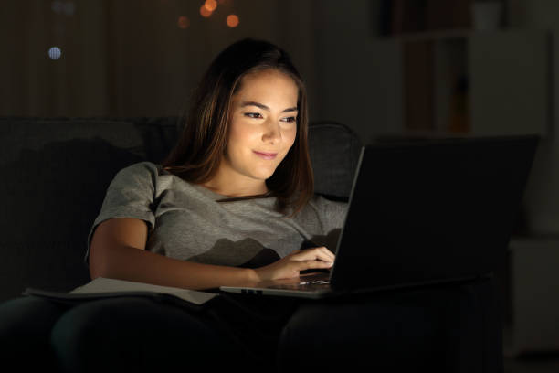 istock Woman using a laptop in the night on a couch 992128238