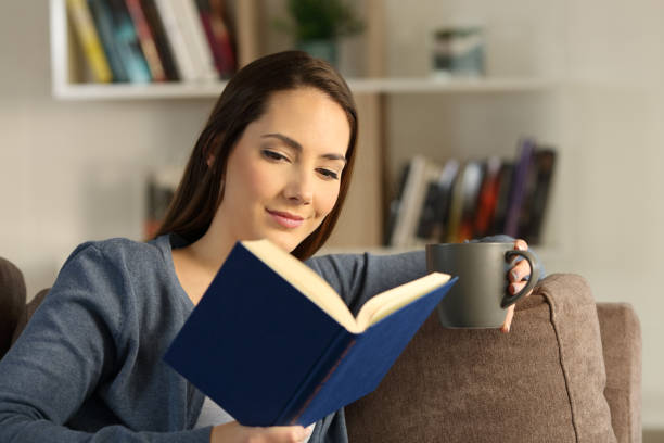 istock Woman reading a book relaxing at home 992128340