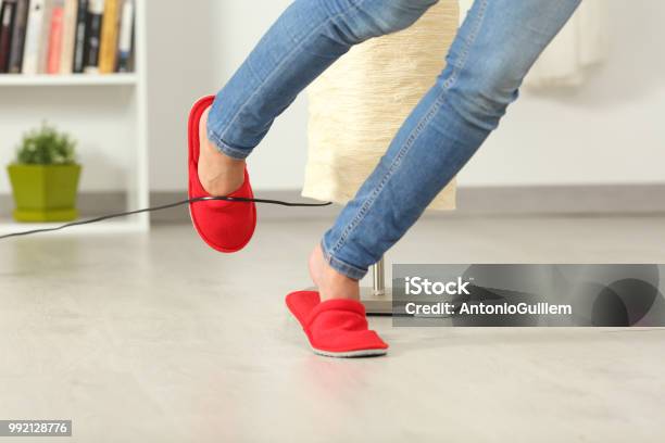 Woman Stumbling With An Electrical Cord At Home Stock Photo - Download Image Now - Misfortune, Falling, Crash