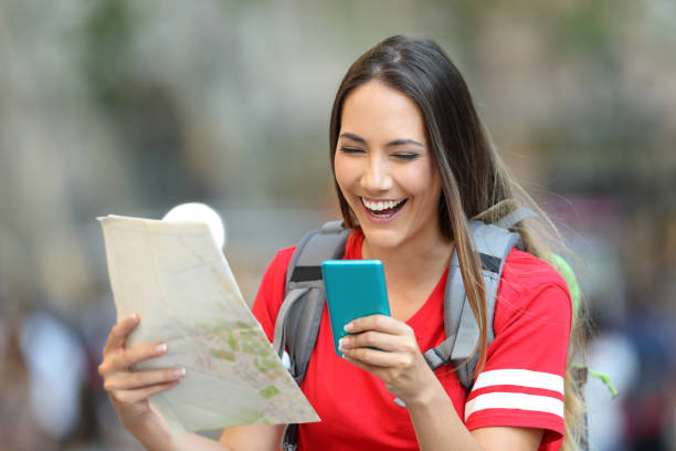 istock Teen tourist using a phone and holding a map 992128982