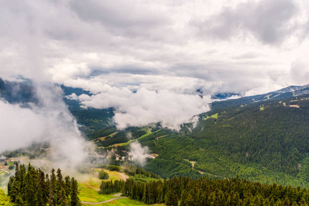 vista de cima na espessas, fofas nuvens brancas sobre montanhas arborizadas com estradas rurais - 3670 - fotografias e filmes do acervo