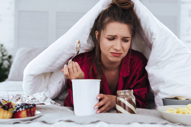 istock Stressed woman eating big ice cream and crying 992134334