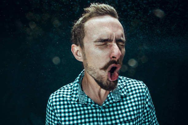 istock Young handsome man with beard sneezing, studio portrait 992134600