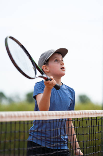 istock boy playing tennis at net 992137438