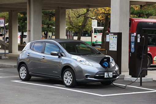 NARA, JAPAN - NOVEMBER 23, 2016: Nissan Leaf electric car charging at a station in Nara, Japan. Zero-emissions vehicles have improved vastly in recent years.