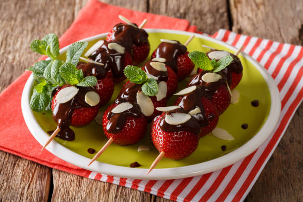 istock Strawberry dessert with chocolate, mint and almonds close-up on a plate. horizontal 992156568