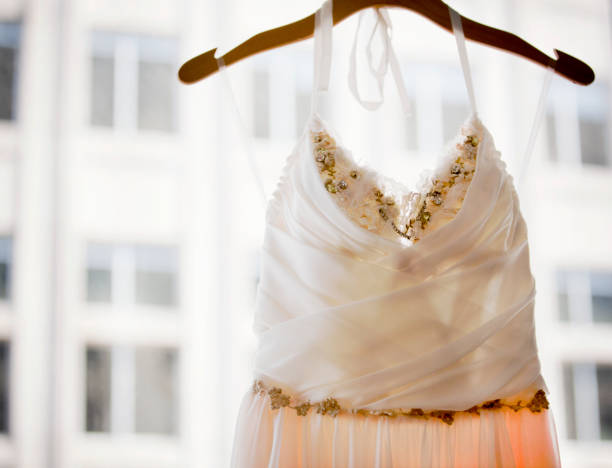 istock Beautiful beaded wedding dress hanging in a window 992159778