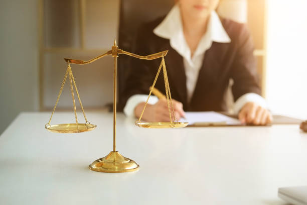 Scale of justice, lawyer in background. justice law lawyer attorney scale weight court authority concept Scale of justice, lawyer in background. justice law lawyer attorney scale weight court authority concept female lawyer stock pictures, royalty-free photos & images