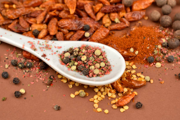 Hot peppers and pepper images. Mixture of spices images. Spice mix on a brown background. Aromatic spice collection. Spicy spice on a spoon. Spicy seasoning still life