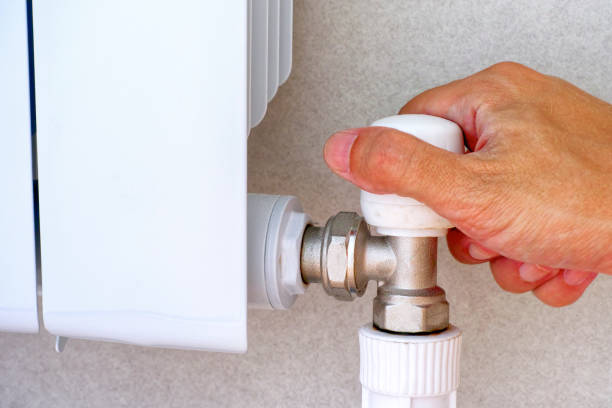 istock Person hand on adjuster of heating radiator. 992213150